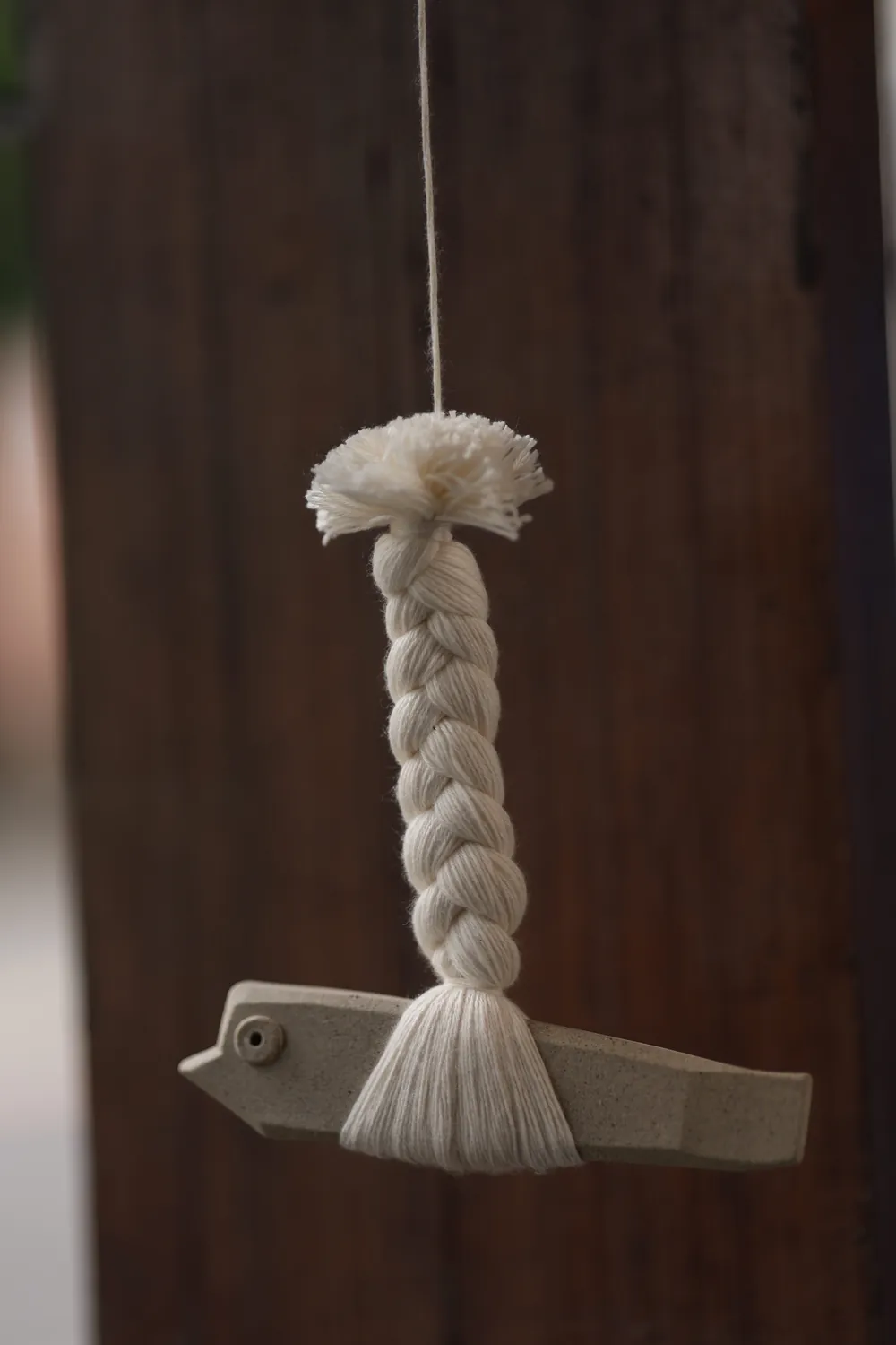 A stoneware fish hanging on a braided cotton rope