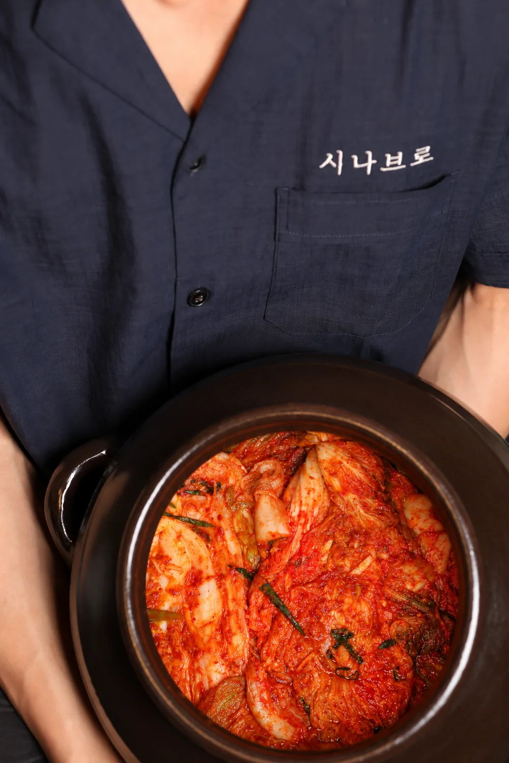Chef carrying a jar of kimchi